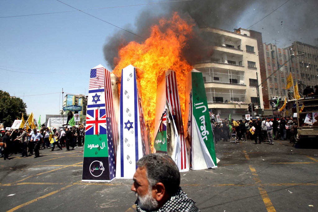 Iranian demonstrators burn flags of the U.S., Britain, Saudi Arabia, Islamic State and Israel during a rally in Tehran on July 10, 2015. (REUTERS/Stringer/TIMA)